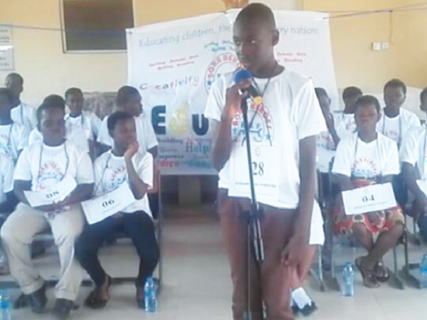Master Richard Adjei-Kyeremateng spelling a word while the other 29 contestants wait patiently for their turn.