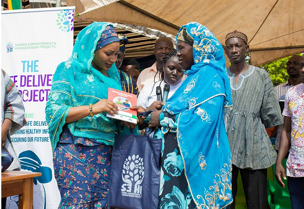 Mrs Samira Bawumia (left) handing over some birth kits to a pregnant woman
