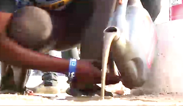 One of the drivers pouring some of the contaminated fuel