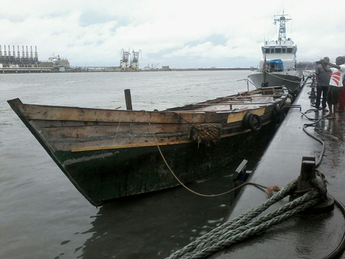 The canoe with the large storage compartment from which the fuel was being pumped. INSET: The fuel tankers into which the fuel was being siphoned
