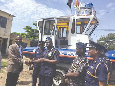 Mr Samuel Ahiadeke (left) handing over the patrol boat to Mr David Asante-Apeatu (third left). Those with them are Police Commander ACP Seidu Iddi (right) and the Director General of Operations of the Ghana Police Service, COP George Mensah (second right) Picture: George Ernest Asare