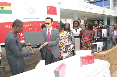 Mr Shi Ting Wang (2nd left), Chinese Ambassador to Ghana, presenting the items to Mr Kwaku Osei Bonsu (left), Ag. General Manager, Ghana News Agency, in Accra. Picture: NII MARTEY M. BOTCHWAY