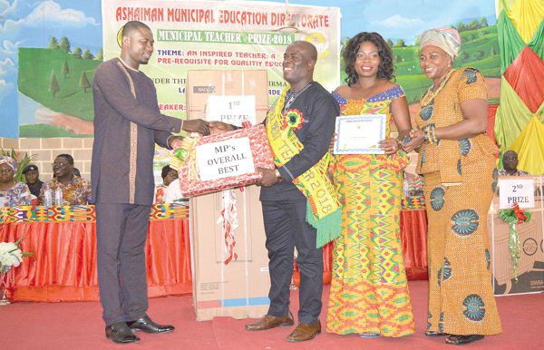  Mr Wallace Bruce (2nd left) receiving the outstanding teacher award from Mr Norgbey, the MP for Ashaiman, with his family members looking on