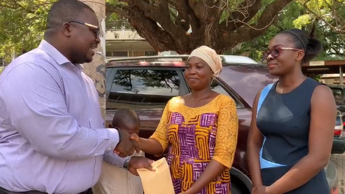 Mr Richard Kissi, the Chief Accountant of CBOD presenting the GH¢3,700 cash to Ms Rosina Buer