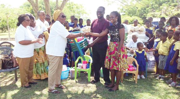 The Vice-President of FAWA, Mrs Elizabeth Wilson (arrowed), in a handshake with Dr Mrs Adraina Arkese of the village. Looking on are some members of FAWA and Rev. Dr Isaac Nana Abekah (2nd right), Director of the village
