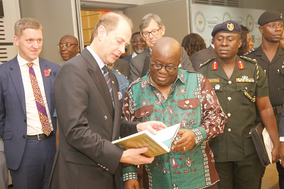 Prince Edward, the Earl of Wessex (2nd left), explaining a point in a book to President Akufo-Addo after the ceremony in Accra
