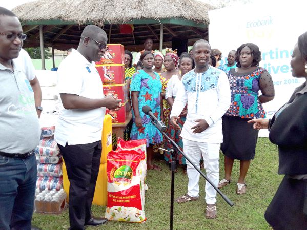 Mr Dan Sackey (2nd left)  presenting the items to Mr Daniel Nartey, a Director of the  Change For Children facility ­