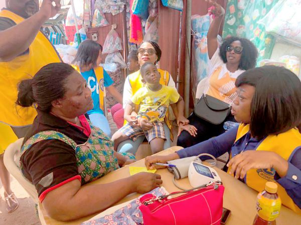 • A trader (left) being  screened by a Lion at the Nungua market