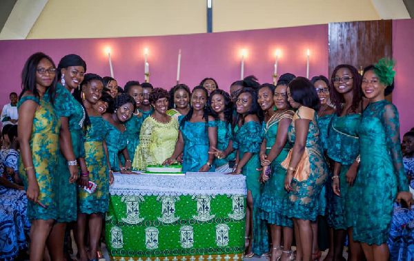 Mrs Juliana Konadu, President of Accra SLOPSA helping the students to cut the anniversary cake.