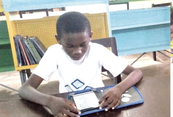    A pupil in Cape Coast, Samuel Ofori Wilson, sampling one of the tablets at the library.