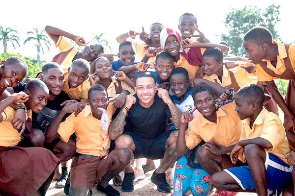  Memphis Depay (squatting) surrounded by some students of the Cape Coast School for the Deaf and the Blind.