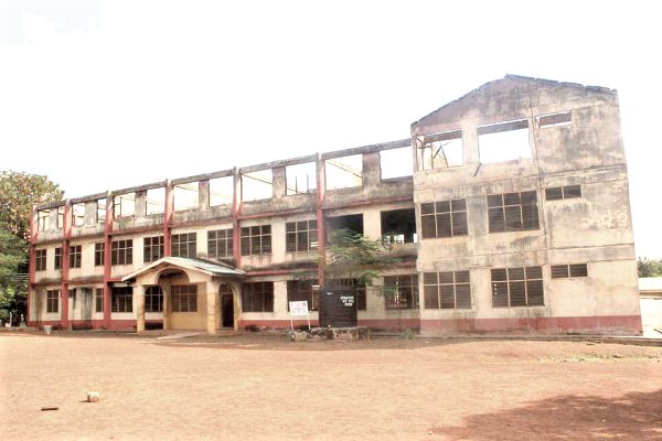  The two-storey dormitory block that was gutted by fire last year.  Inset: The headmaster of the school speaking to the media