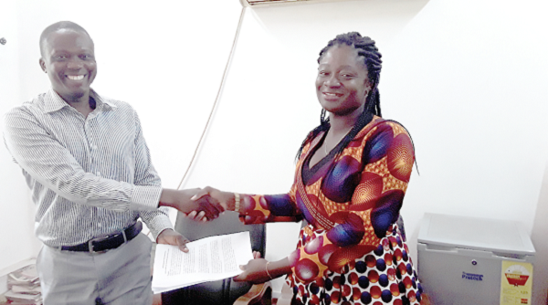  Ms Kosi Yankey, the Executive Director of the NBSSI exchanging the signed MoU with Mr John Asibi Ali, the National Director, CAMFED Ghana