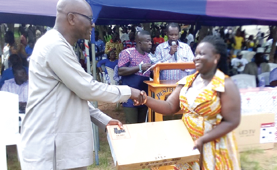  The Member of Parliament for Yilo Krobo constituency, Mr Magnus Kofi Amoatey presenting a laptop computer to Ms Gifty Tetteh of Yilo Krobo Senior High School