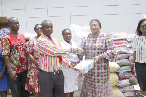  Mrs Rebecca Akufo-Addo presenting some of the items to Mr Elias Wormenor, a teacher at the Akropong School for the Blind
