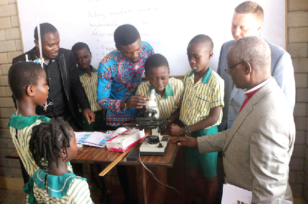 Some pupils of the Trinity Foundation School, familiarising themselves with equipment installed at the newly commissioned science laboratory. Those looking on include the donor, Mr Travis Rutland, and Rev. Samuel Odarno