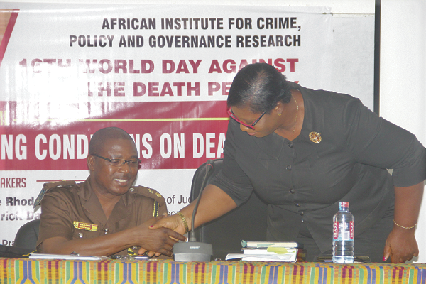 Chief Supt. Thomas Nabila Mahama (left) in a handshake with Ms Joyce Adu at the event  Picture: MAXWELL OCLOO