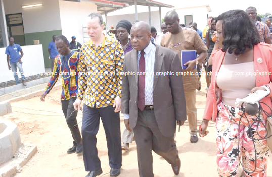 Mr Kwaku Agyemang-Manu (2nd left) and Mr Albert Tackie (left) touring the Sege Polyclinic project. INSET: A view of the Sege Municipal Polyclinic 