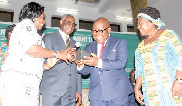 Mrs Adelaide Benneh presenting a gift on behalf of the University of Ghana Alumni Association (UGAA) to Prof. Aaron Michael Oquaye (2nd right). Also in the picture are Mr Eric Obeng Okrah (2nd left), Chairman of the UGAA, and Mrs Alberta Oquaye (right).