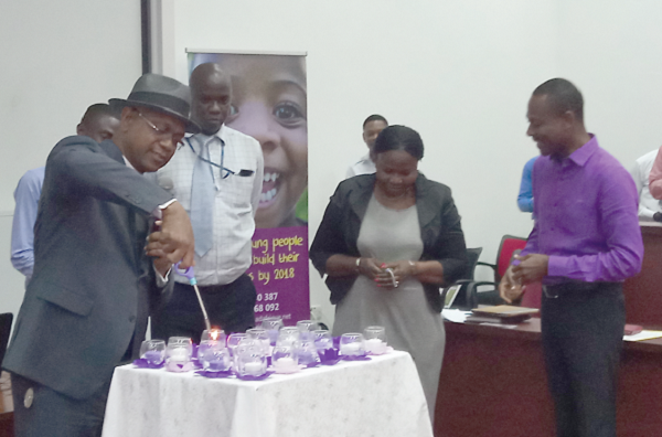 Reverend Kennedy Okosun (left)lights a candle  to launch the competition