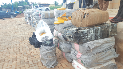 Bags of the impounded exhibits suspected to be Indian hemp. INSET: ACP Mr Acheampong briefing the media