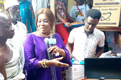 Mrs Queenstar Maame Pokuah Sawyerr (middle), presenting the computers and accessories to Nana Ayiah III (left)