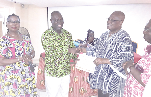 Dr Yaw Baah (2nd left), Secretary General of the TUC, presenting the certificate of affiliation to Mr Edward Ameyibor, acting Executive Secretary of the Amalgamation of Pensioners and Retired Officers Association 