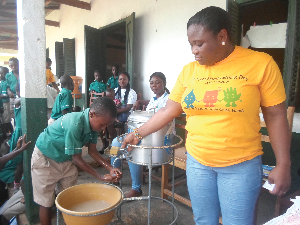  A Senior Extension Service Specialist at the Community Water and Sanitation Agency (CWSA) teaching a pupil of the school how to properly wash his hands