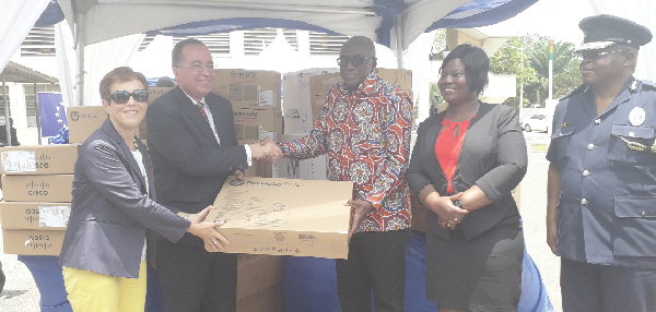 The Executive Director of Partnership and Planning, INTERPOL Secretariat, Mr Carl Alexandre (2nd left), handing over a scanner to the Minister of the Interior, Mr Ambrose Dery  Looking on are the EU Ambassador, Madam Diana Acconcia (1st left), and the Director-General of the CID, Mrs Maame Yaa Tiwaa Addo-Danquah (1st right).