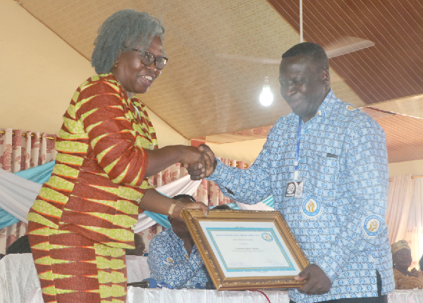  Mr Penros Ofosu, the longest-serving employee of the bank, receiving his reward from a board member