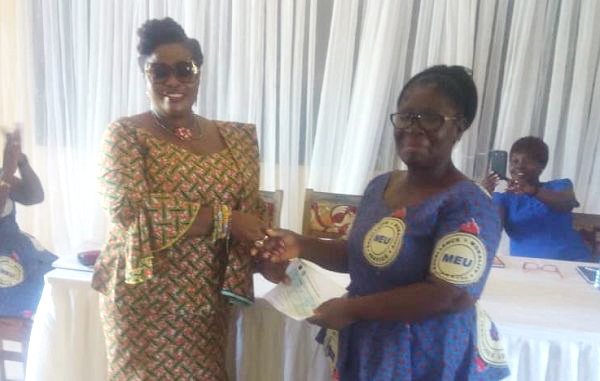 Ms Amegashie (in spectacles) presenting the cheque to Madam Yalley