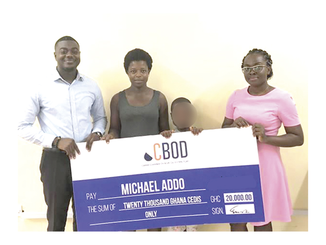 Mr Dennis Dei-Tutu (left) and Ms Angela Osei-Badu (right), both of CBOD, presenting a dummy cheque to Master Michael Addo (face covered), accompanied by his mother, Ms Olivia Bansah