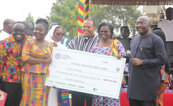 Vice President Dr Mahamudu Bawumia, (right), presenting a dummy cheque to Ms Augusta Lartey-Young (2nd left), first runner up of the Ghana Teacher Prize