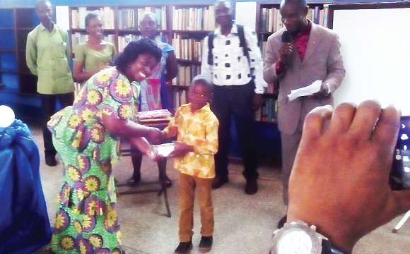 Ms Arthur (left) presenting an award to Master Alexander Fianko, who won the reading and spelling competition 
