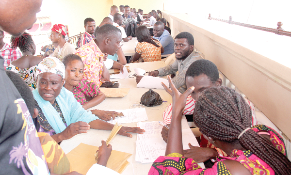 Some officials from the Free SHS Secretariat assisting parents with complaints during a visit to the centre. Picture: EDNA ADU-SERWAA