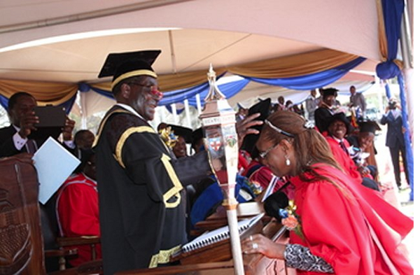  President Mugabe capping his wife, DR Grace Mugabe, at the 2014 Congregation