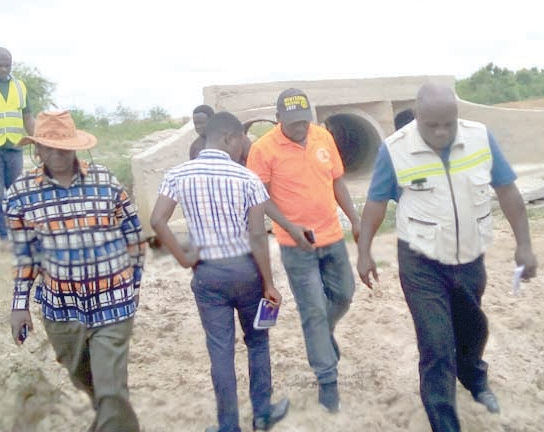 Mr. Joseph Miezah (right), the Greater Accra Regional Director of Feeder Roads,  and Mr Adzoteye Lawer Akrofi (left), the DCE for Ada West,  inspecting damaged portions of the road
