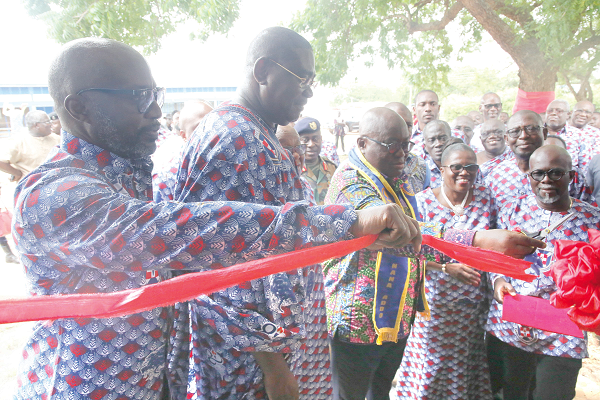 President Nana Addo Dankwa Akufo-Addo (3rd left) being assisted by Mr Frank Adu Jnr (left), the Managing Director of Cal Bank and alumnus of the school, and Lady Queene Asiedu Akrofi, to cut a tape to inaugurate a library for the school. Picture: SAMUEL TEI ADANO