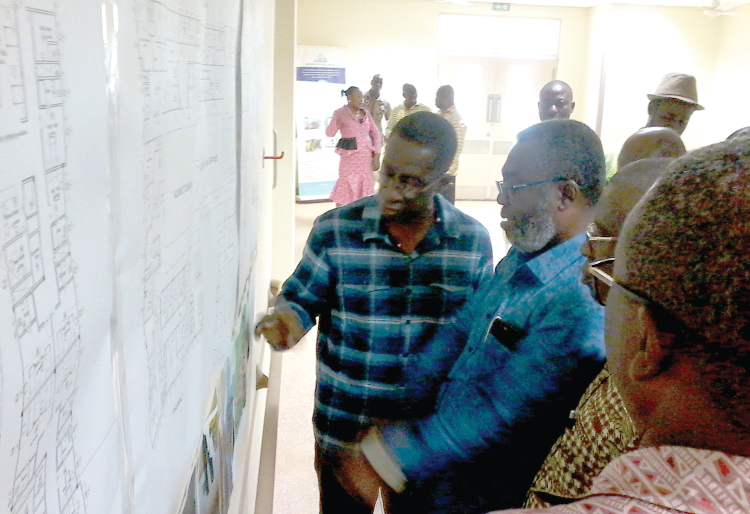 Mr Theodore Kanyi, an architect with Saud Consult/Daovtech, briefing Dr Nsiah Asare (2nd left) on the progress of work on the Bolga Regional Hospital