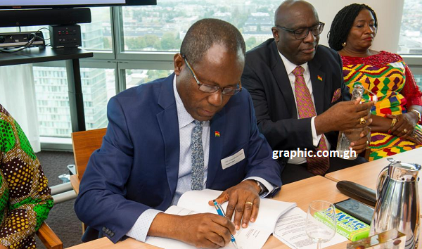 Mr Joseph Boahen Aidoo, the CEO of COCOBOD, signing the agreement on behalf of COCOBOD. Those with him are Mr Papa Owusu Ankomah, Ghana's High Commission to UK, and Nana Adwoa Dokua, a board member of COCOBOD. 