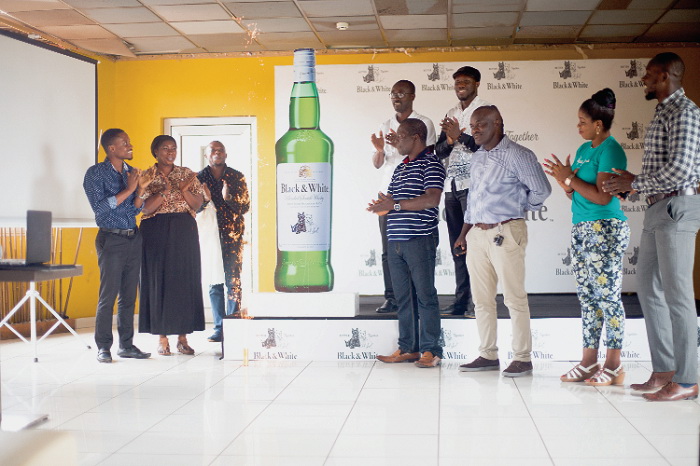 Mr Gilbert Tweneboah-Kodua (1st left), Innovations Manager, GGBL, Mr Kofi Allaglo (arrowed), with other workers and customers of GGBL unveiling the new product