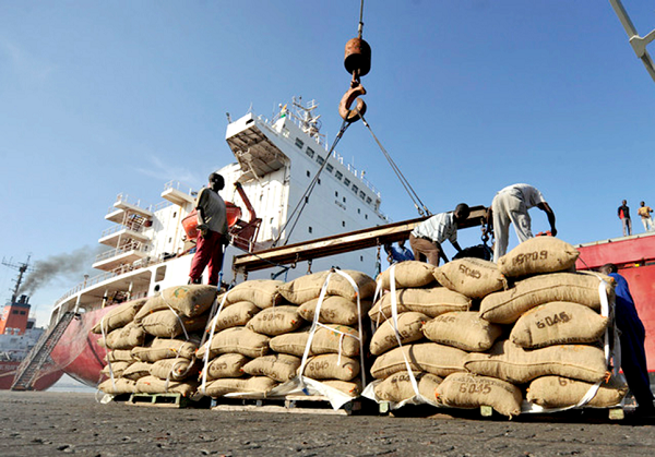 •  Cocoa beans being loaded onto a ship