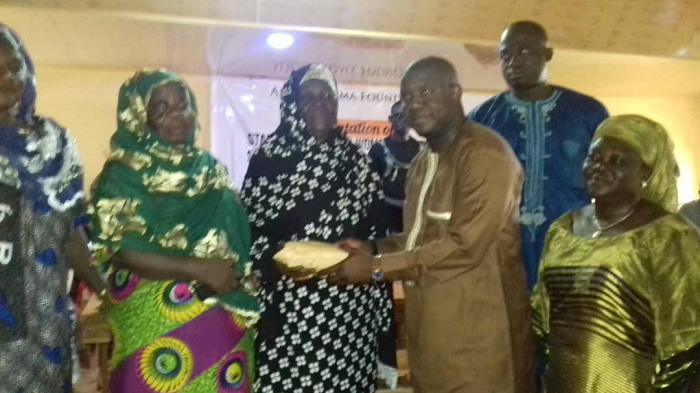 Alhaji Farouk Mahama presenting the money to the leader of the women's group at Yendi