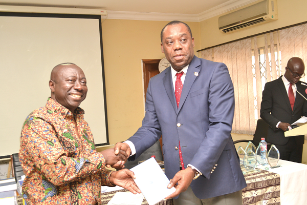 Mr Kwame Owusu (left) presenting a copy of the textbook to Dr Matthew Opoku Prempeh