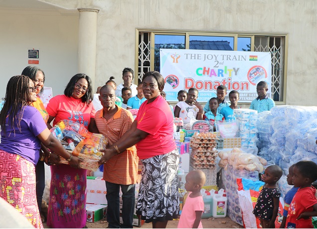 A founder of The Joy Train, Mrs Mabel Amoako–Atta presenting the items to founder of Nyamedua Children’s Home Mr Paul Anaba .