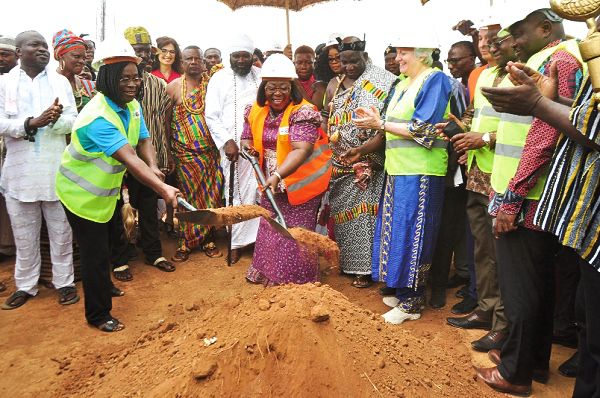 Professor Yaa Ntiamoa-Baido (left) and Mrs Frema Opare cut the sod for the commencement of the construction of the Bulk Supply Point at Pokuase as some dignitaries cheer them on 