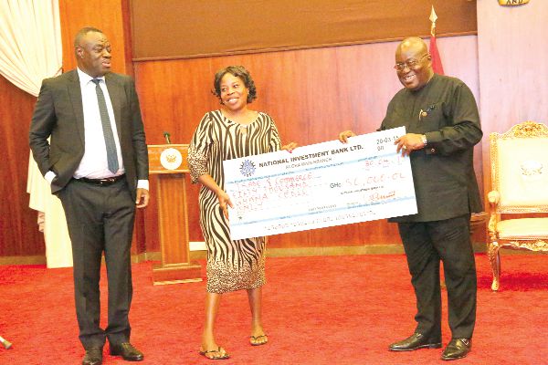  President Nana Addo Dankwa Akufo-Addo presenting  a dummy cheque to Mad Beatrice Yeboa (2nd left), representing women entrepreneurs with disabilities. Looking on is Dr Mohammed Ibrahim Awal, the Minister of Business Development. Picture: SAMUEL TEI ADANO