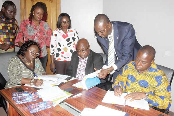Mrs Ellen Bannerman-Quist (left), the Director, Legal Services, Volta River Authority (VRA), and Mr John Allotey (right), Deputy Chief Executive of Forestry Commission (FC), signing the memorandum of understanding. Sitting in the middle is Mr Ebenezer Tagoe, the Deputy Chief Executive, VRA.  Picture: Maxwell Ocloo