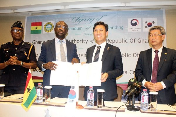 Mr Emmanuel Kofi Nti, (2nd left), Commissioner-General of the GRA, and Mr Kim Young Moon, Commissioner of the South Korea Customs Service, exchanging documents after appending their signatures to the MoU