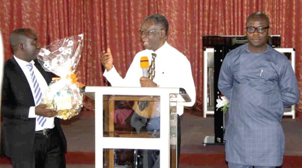 Rev. Daniel Nyarko (right), the Chairman of the Ga West Presbytery of the PCG, dedicating the books to God
